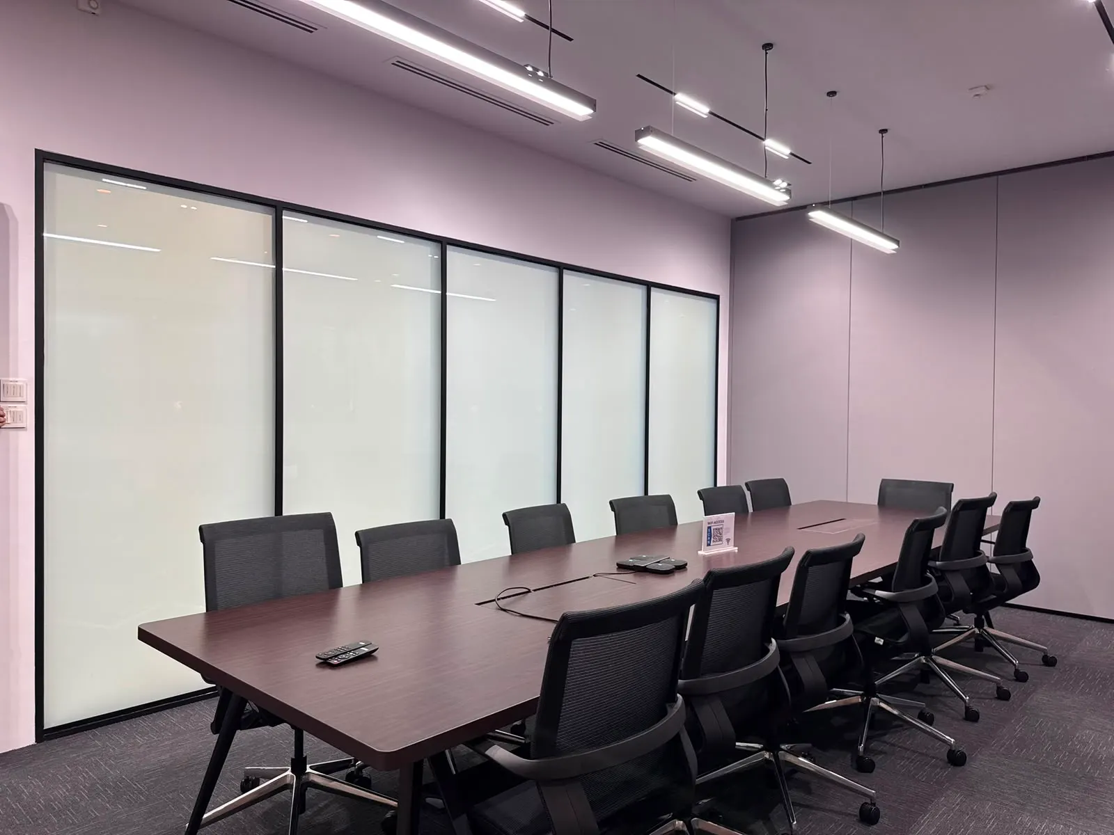 A Singapore boardroom whose existing glass partition has Smart Film applied, switched to its frosted privacy state