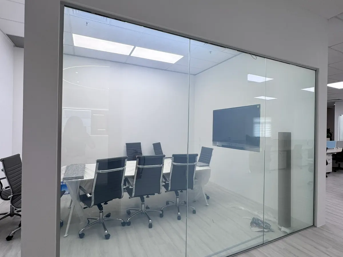 Smart Glass meeting room partition in a Singapore office, switched clear so the boardroom is visible