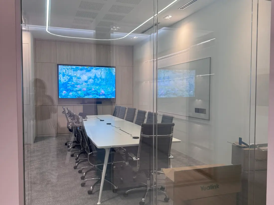 Quasar office meeting room with Smart Glass partition switched clear, boardroom table visible