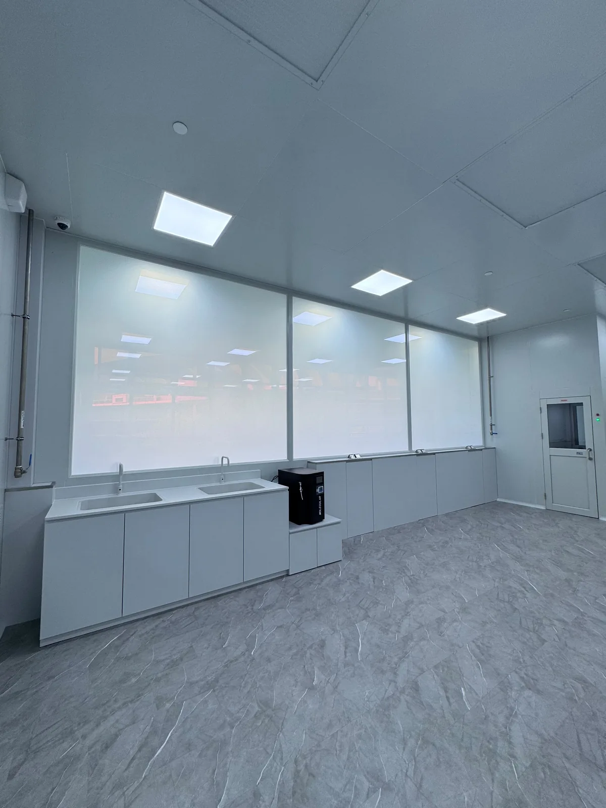 Private-mode smart film installed across laboratory glazing in a clean technical workspace