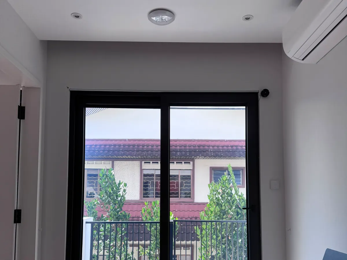 Smart film on a residential balcony door in clear mode, garden and greenery visible from the living area