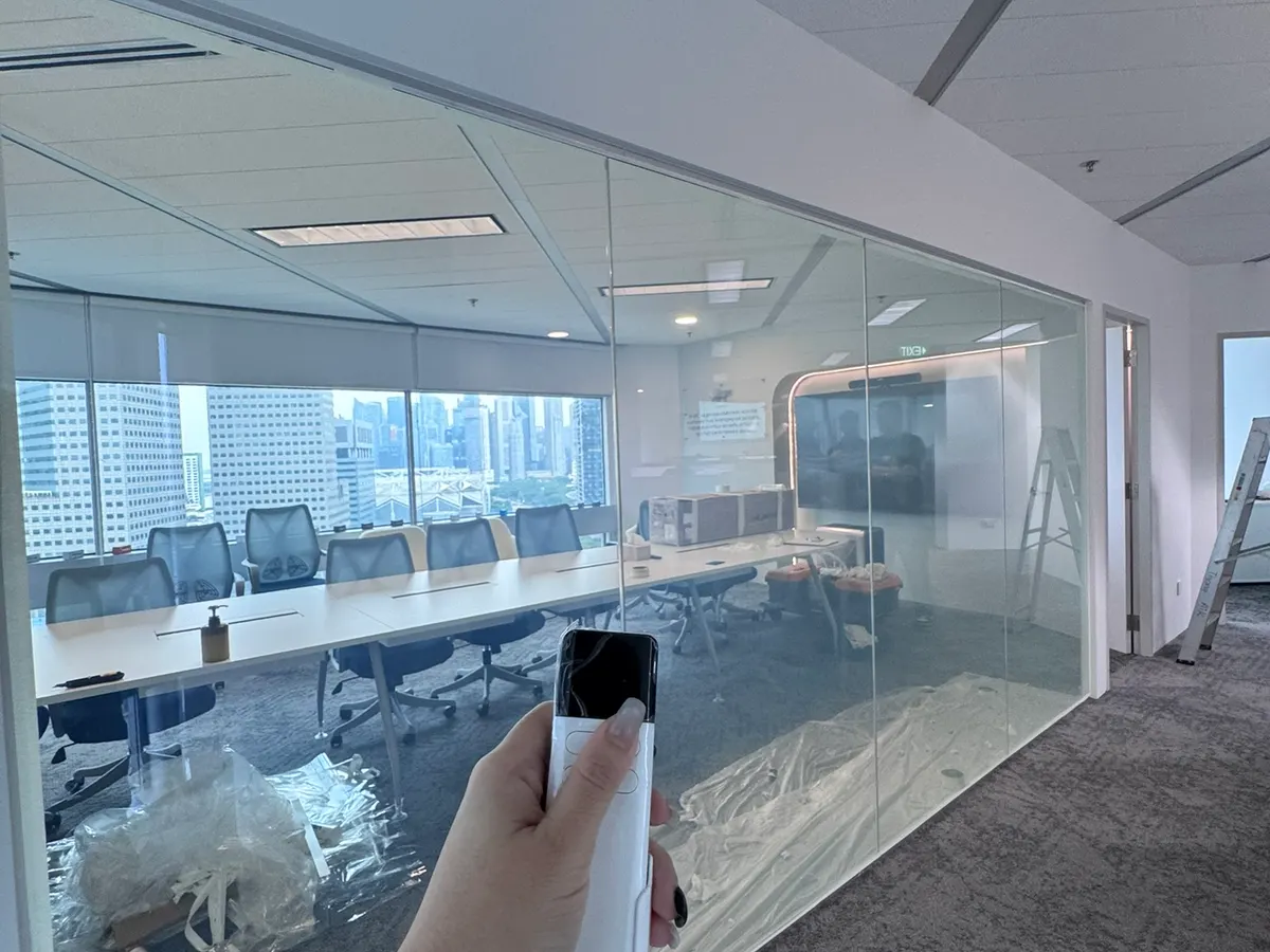 Smart film on a Singapore office meeting room glass partition in clear mode, boardroom table and waterfront view visible