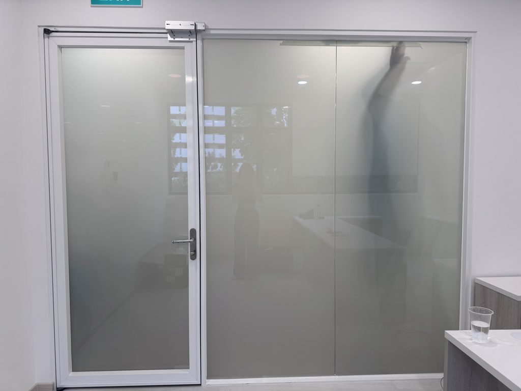 Smart film glass partition showing the frosted privacy state beside the clearer state in the same installation